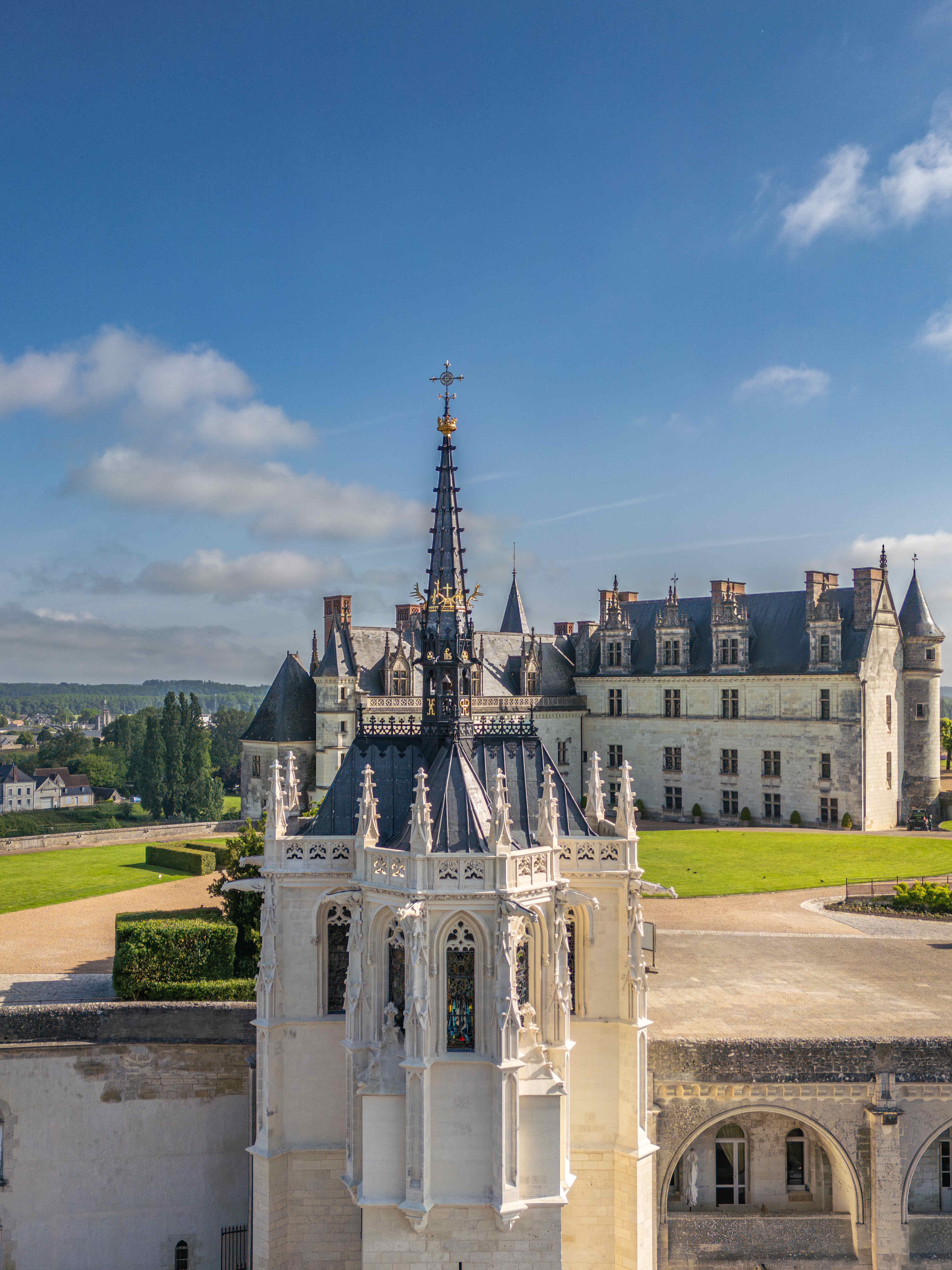 La chapelle au premier plan et le Château royal d'Amboise à l'arrière-plan, sous un ciel bleu — © Erwan Fiquet 2024.